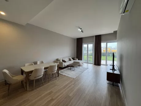 View of a spacious and bright furnished living room decorated with modern furniture.