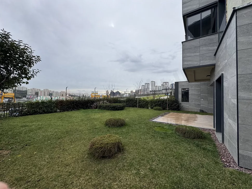 Landscaped spacious garden area of a modern residential complex surrounded by green plants.