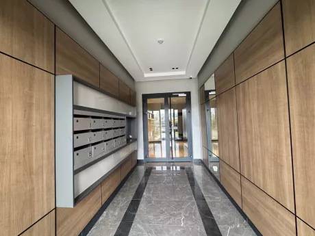 A modern and spacious apartment lobby with stylish lighting and a waiting area.