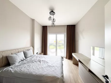 View of a spacious and bright bedroom decorated with modern furniture.