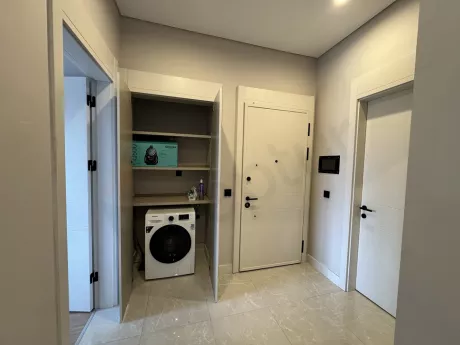 Modern and organized laundry room design with washing machine and storage cabinets