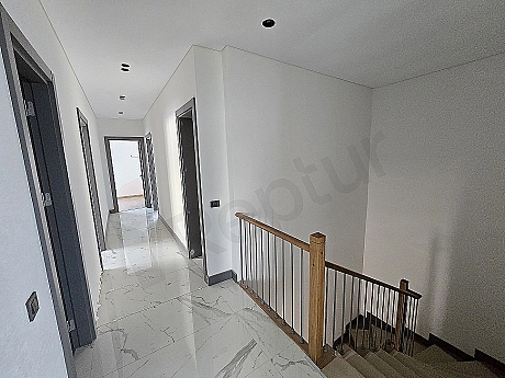 Interior view of a spacious and bright villa corridor.