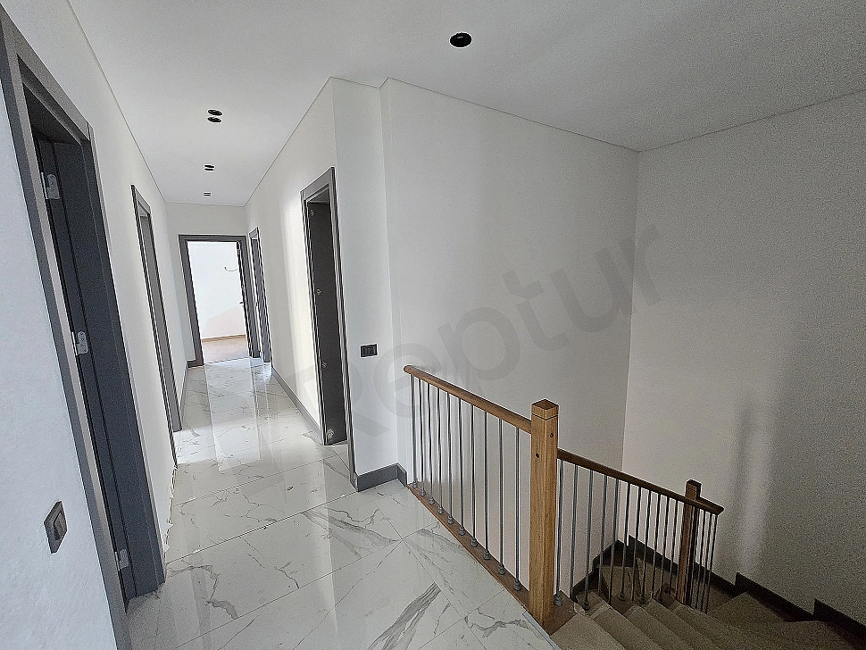 Interior view of a spacious and bright villa corridor.