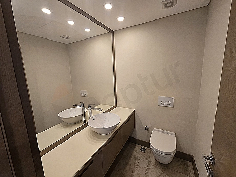 Image of a modern designed duplex apartment bathroom with luxurious details. White ceramics, large shower cabin, and stylish lighting.