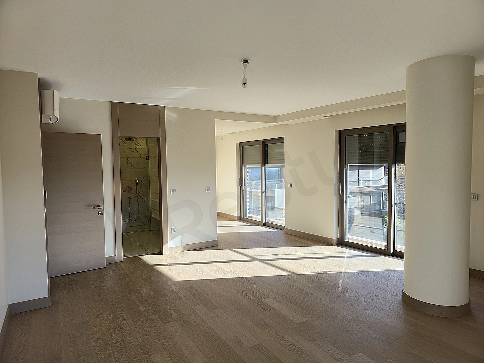 Stylish and modern bedroom interior, with a large double bed, bedside tables with lamps, rug, curtains, and painting details.