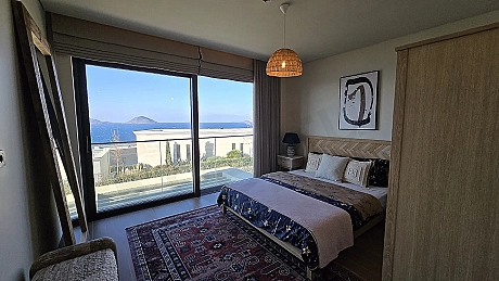 Spacious bedroom interior with a modern design and large windows.