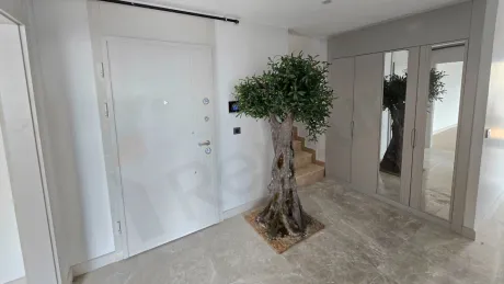 Wide-angle view of the entrance door and hallway area of a modern apartment.