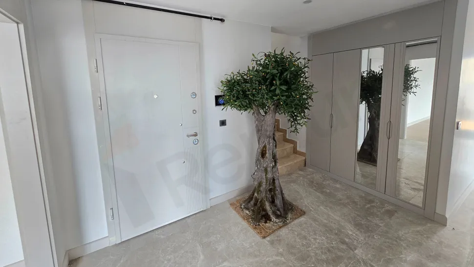 Wide-angle view of the entrance door and hallway area of a modern apartment.