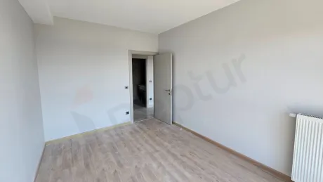 Modern and empty bedroom area with large windows and natural light.
