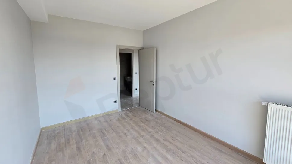 Modern and empty bedroom area with large windows and natural light.