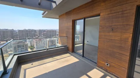 Spacious and modern balcony of a duplex apartment with a city view.