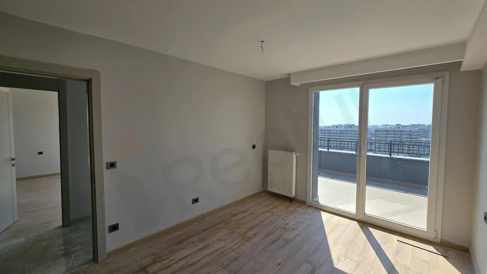 A spacious bedroom view featuring large windows, modern ceiling lighting, and high-quality flooring.