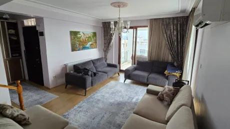A spacious and bright living room with modern design and large windows capturing natural light.