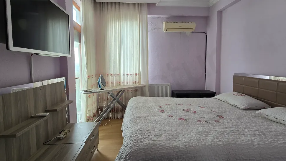 Image of a spacious and sunlit bedroom in a duplex apartment with a sea view in Bodrum.
