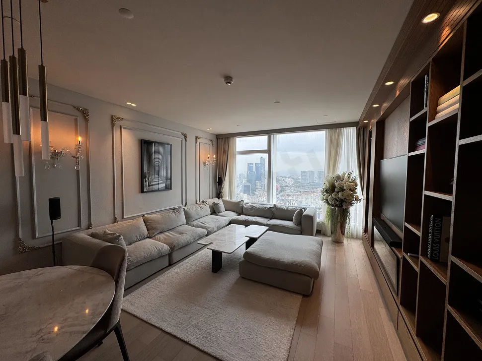 Living room image of a spacious 2+1 apartment furnished with stylish and modern furniture and large windows.