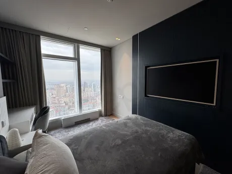 View of a stylish and spacious bedroom decorated with modern furniture.