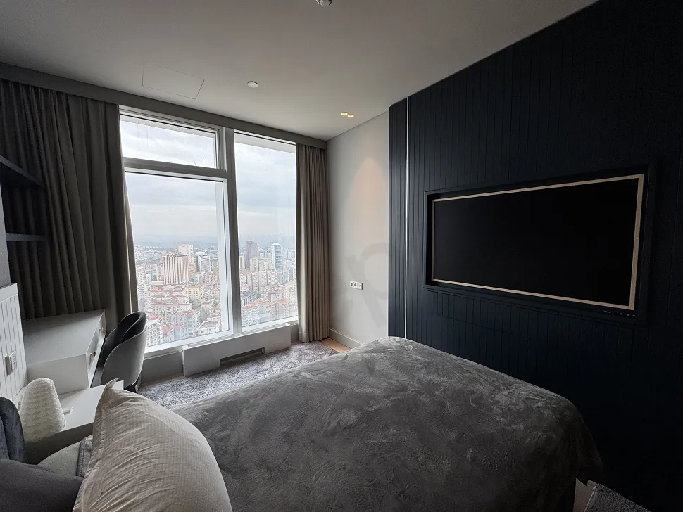 View of a stylish and spacious bedroom decorated with modern furniture.