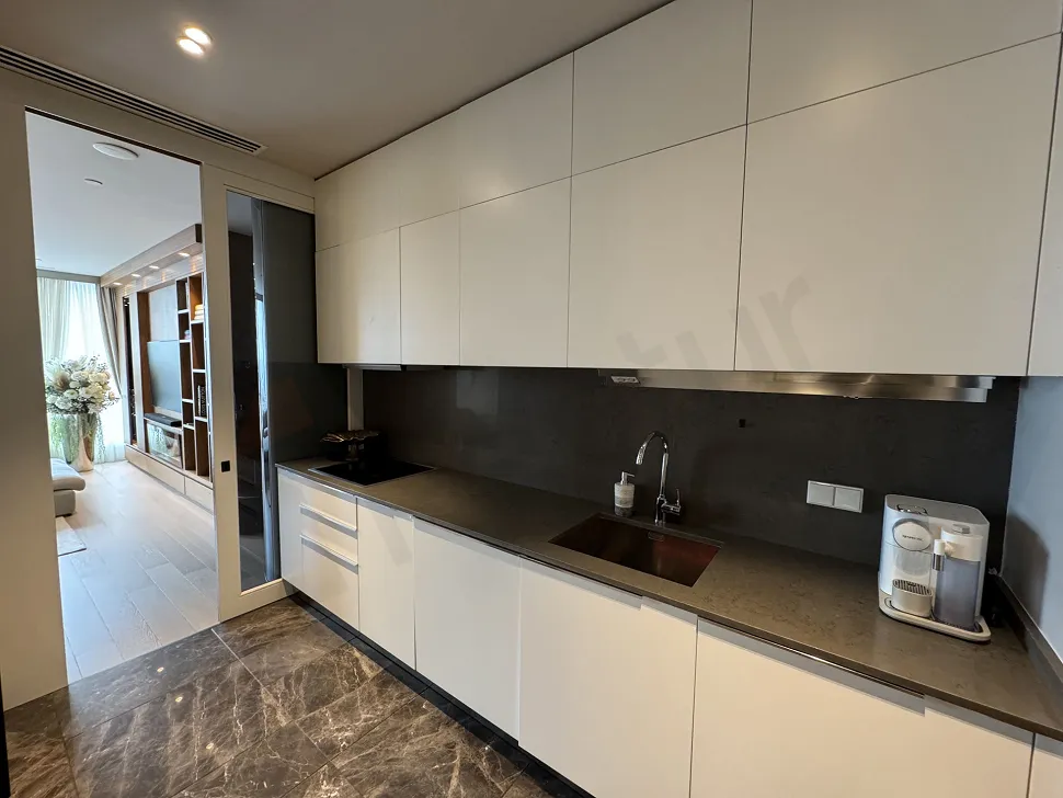 A modern designed kitchen area featuring stylish cabinets, countertops, and contemporary furniture.