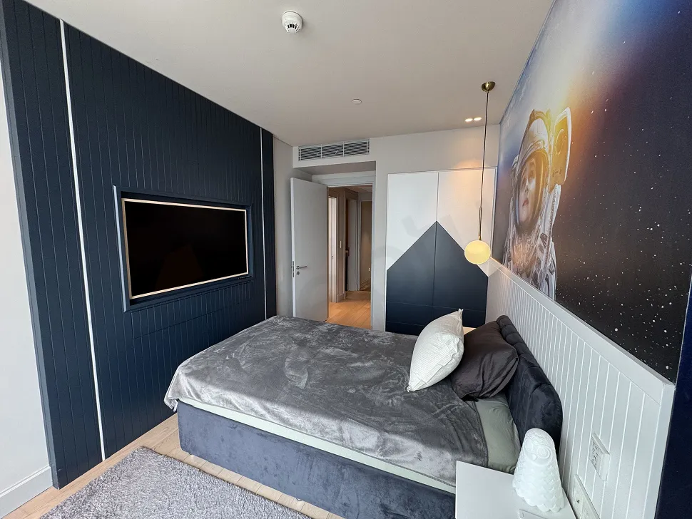 A stylish and spacious bedroom design furnished with modern furniture and natural lighting.