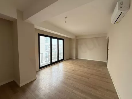 Modern and spacious living room view with large windows and natural light.